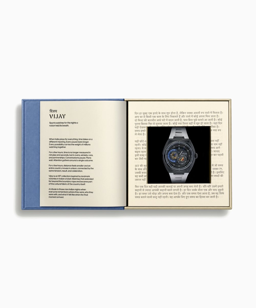 IST 1947 Vijay presentation box opened like a book, with the collection's introduction on the left page and the watch set into a page of Hindi text on the right